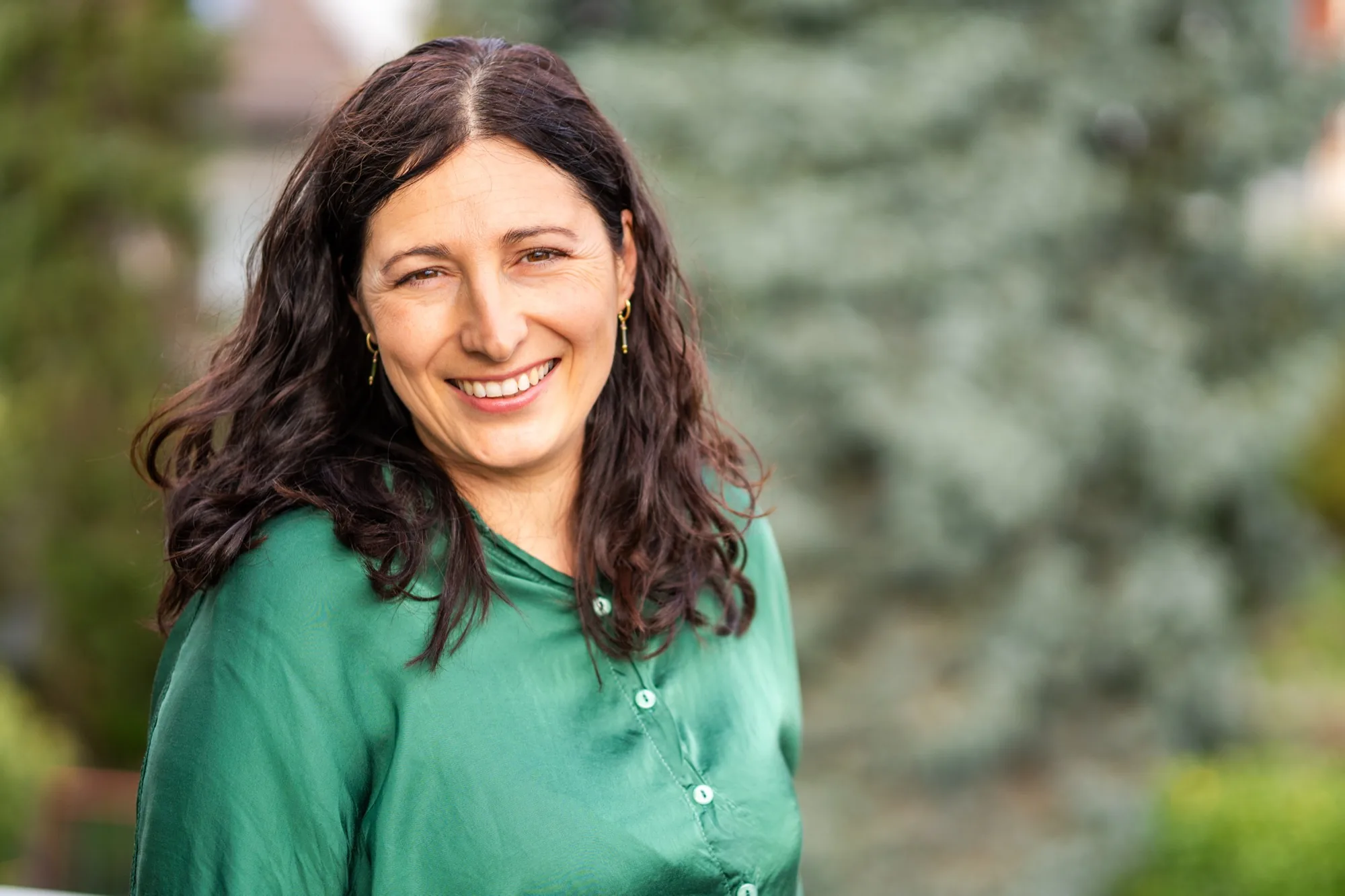 Natascha Krings-Stern, lächelnd vor Grün im Garten